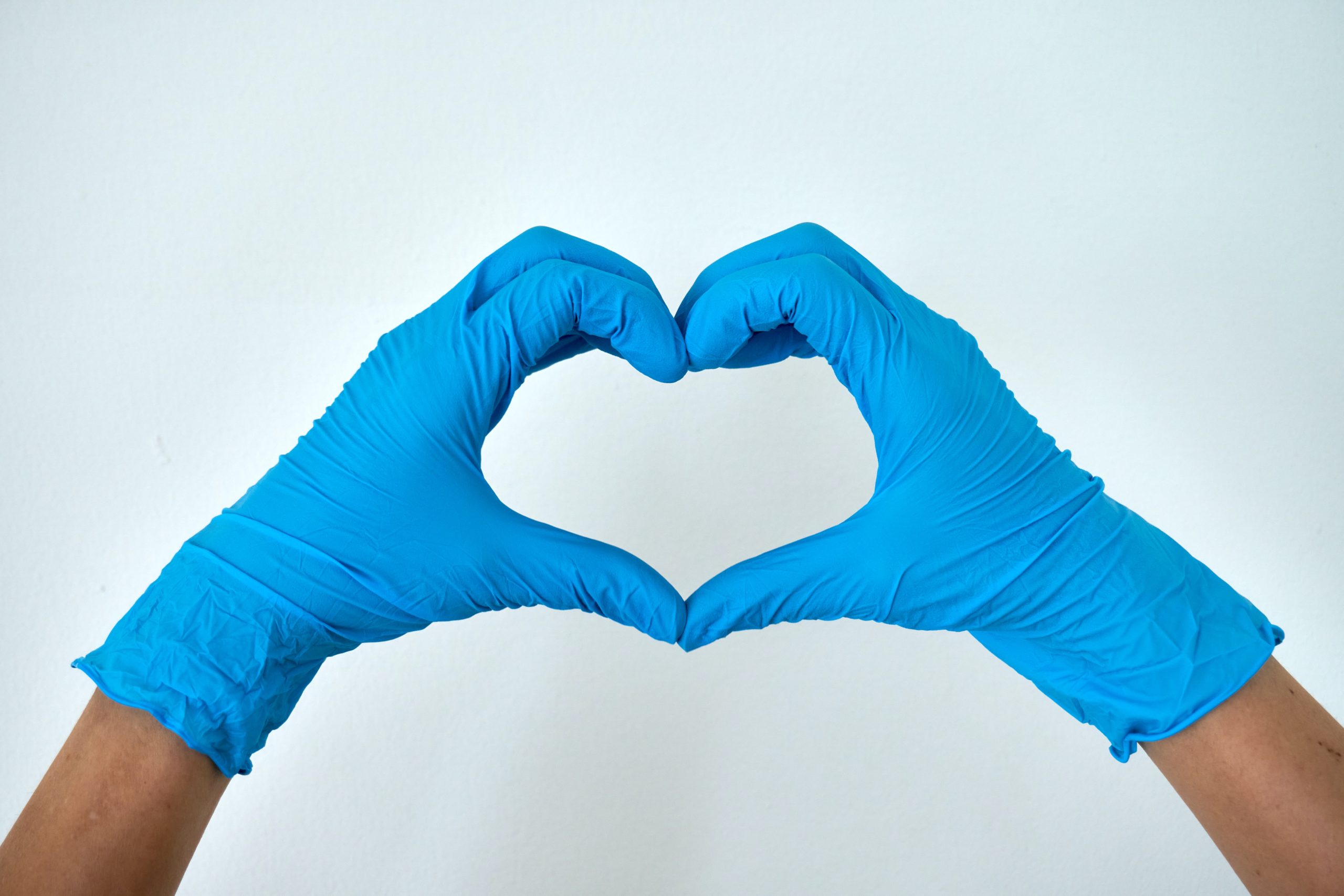 person making heart with hands with latex gloves on
