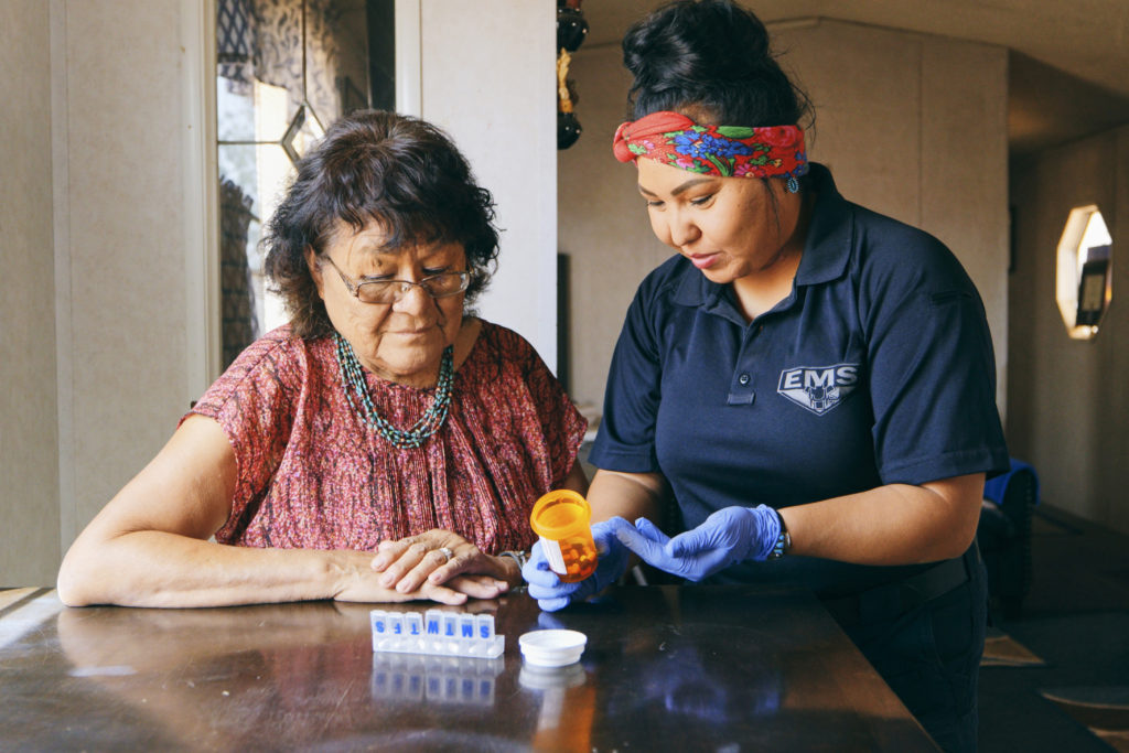 An Indigenous Navajo senior aged woman, receiving healthcare assistance in her home.